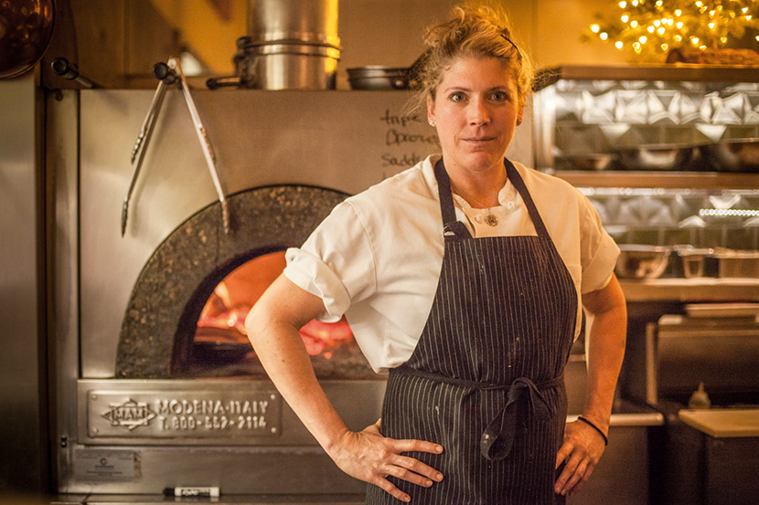 Kathryne Bennett in front of a wood fired oven
